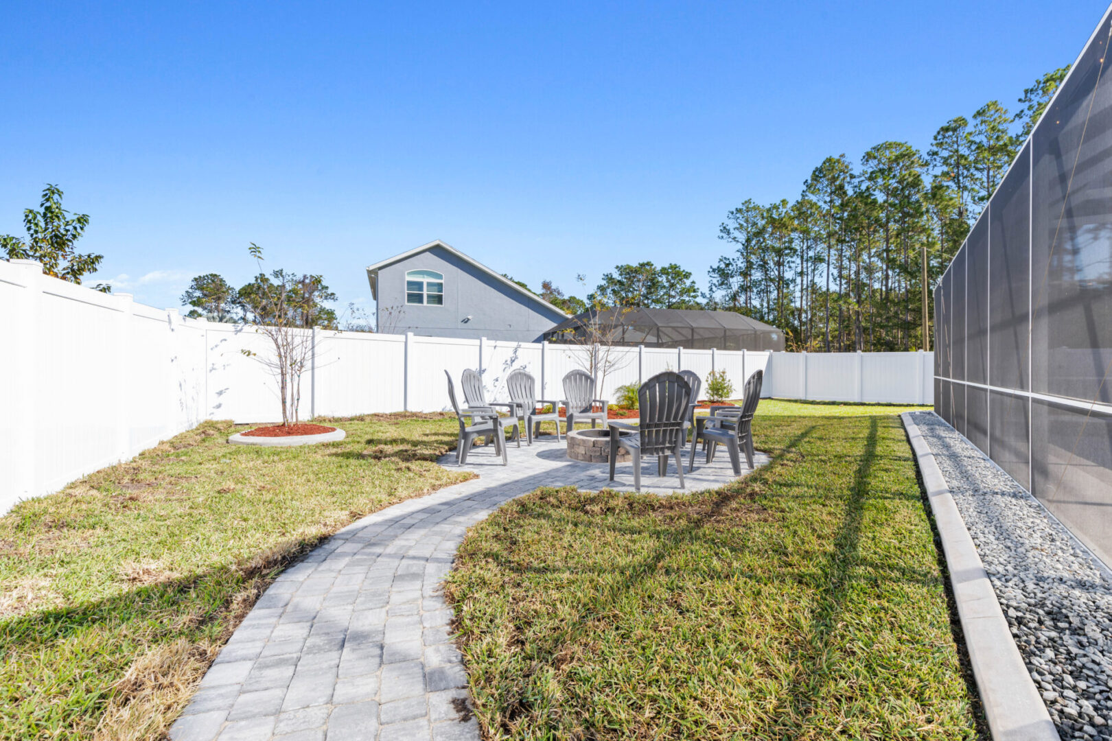 A backyard with a lawn and patio furniture.