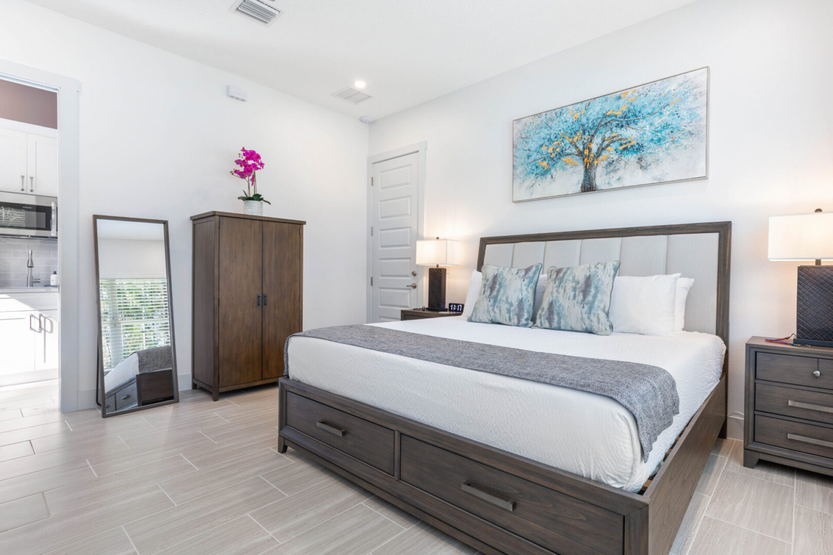 A bedroom with a bed, dresser and nightstand.