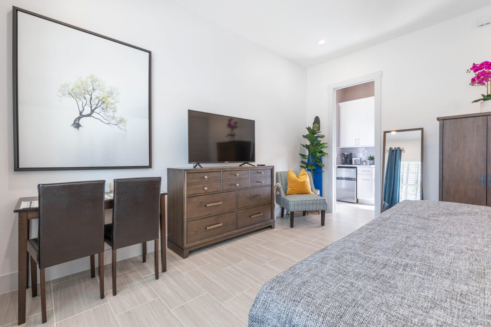 A bedroom with a bed, tv and table in it.