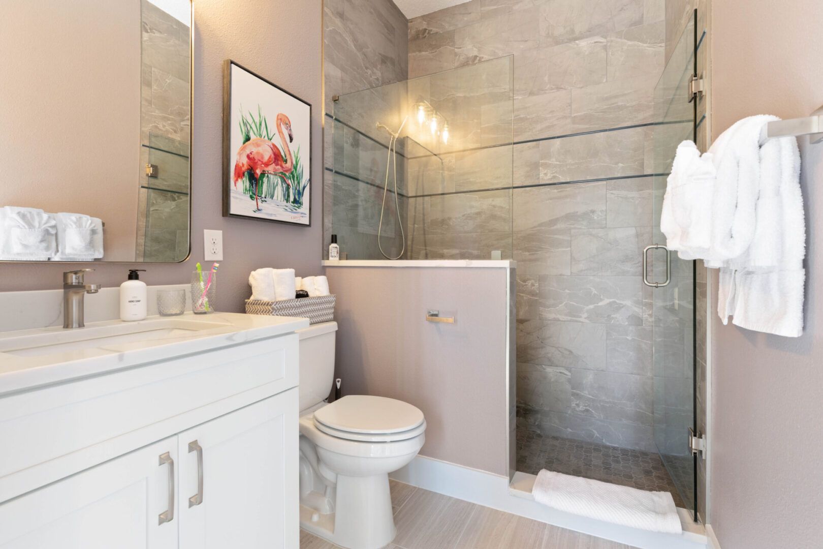 A bathroom with a toilet, sink and mirror.